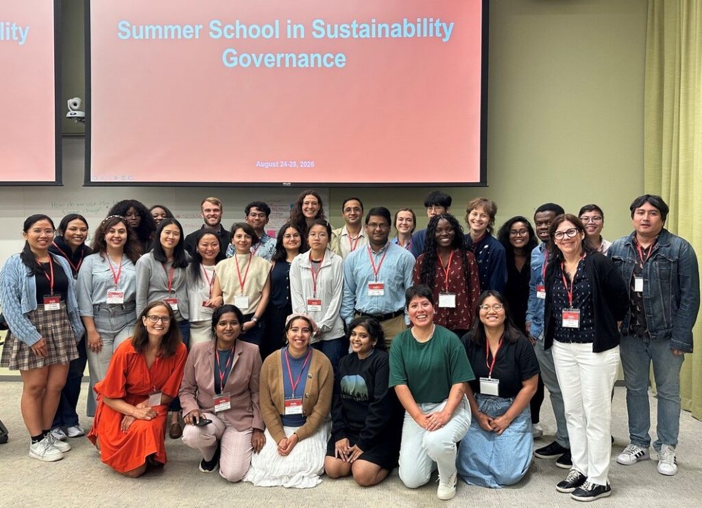 picture of about 30 people of all genders and ethnicities dressed business casual in front of a sign that says Rutgers Sustainability Governance Summer school